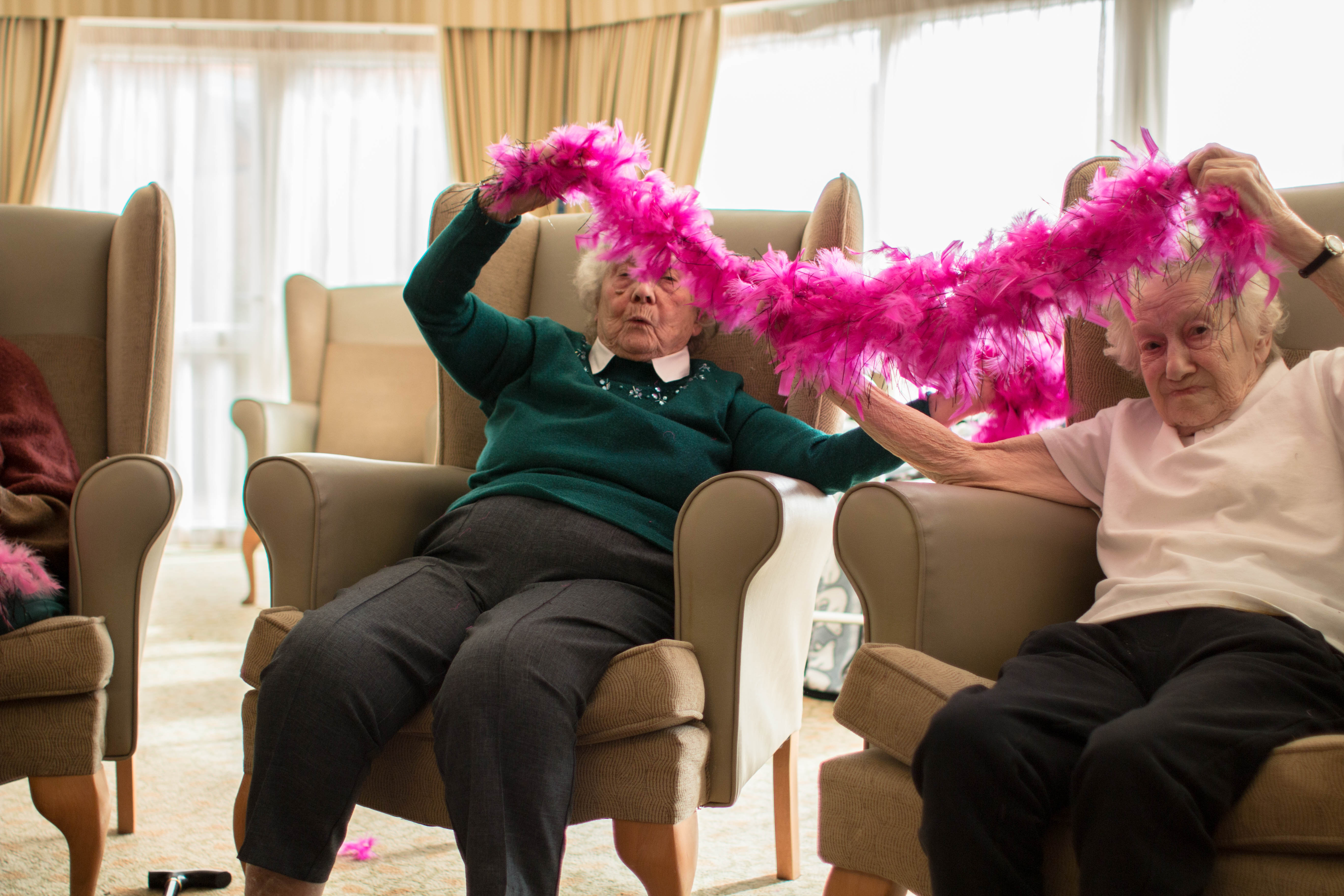 Craig Healthcare West Farm Care Home armchair aerobics ladies having fun with feathers